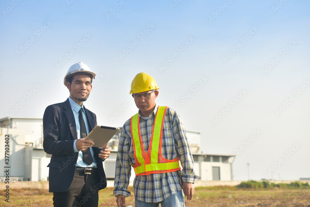 Asian Engineer using tablet working on site construction Asian Engineer using tablet working on site construction