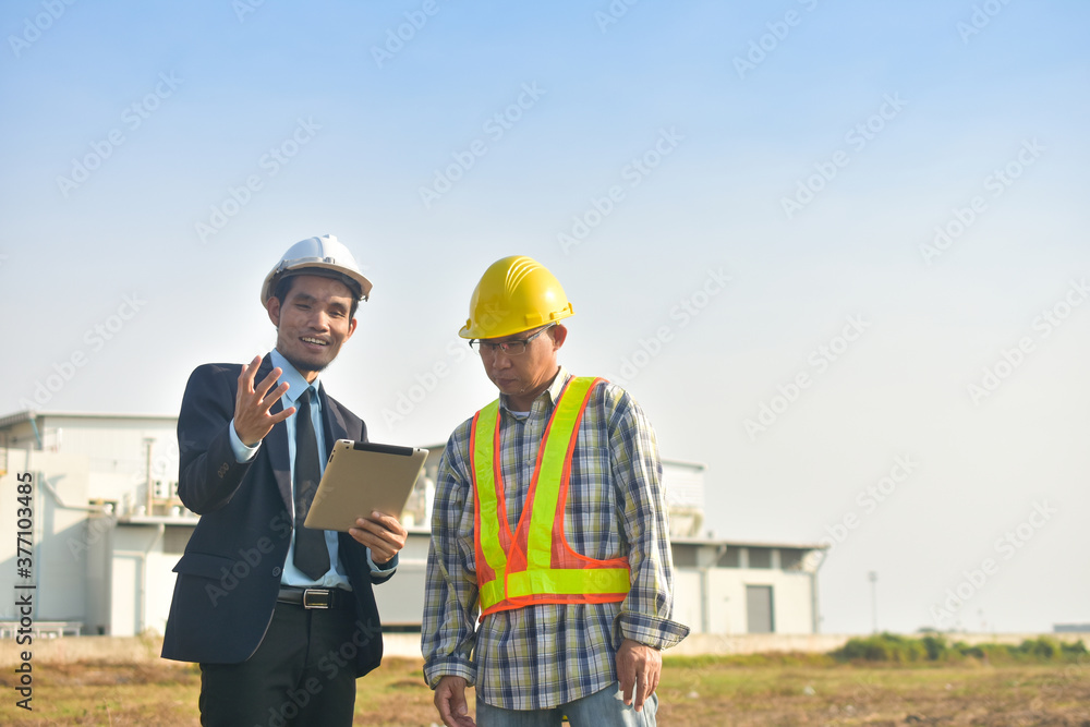 Asian Engineer using tablet working on site construction Asian Engineer using tablet working on site construction