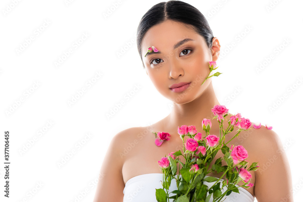 sensual asian woman with flowers on face and petals on shoulder near pink roses isolated on white sensual asian woman with flowers on face and petals on shoulder near pink roses isolated on white