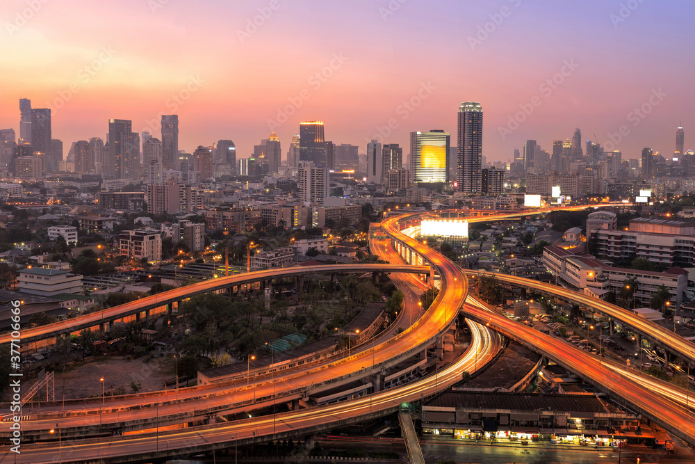 Modern office buildings, condominium in big city downtown with Motorway, Expressway, Freeway the infrastructure for transportation in modern city, urban view at twilight time