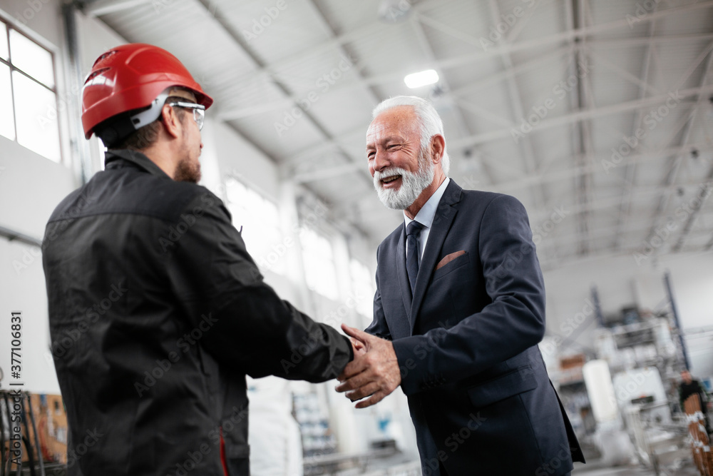 Colleagues working together. Arhitect and worker handshake in factory. Colleagues working together. Arhitect and worker handshake in factory.