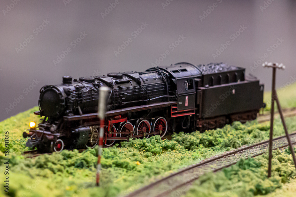 A steam locomotive maneuvering on a railway siding. Model of a steam locomotive at a railway station. A steam locomotive maneuvering on a railway siding. Model of a steam locomotive at a railway station.