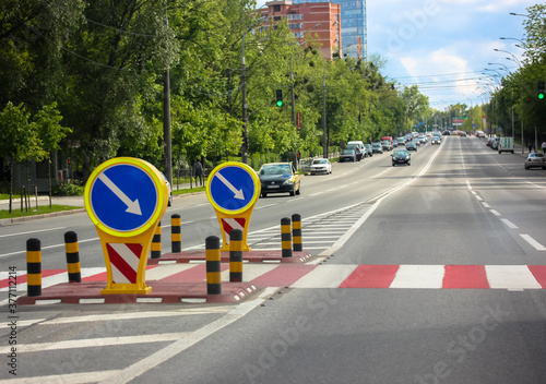 Crosswalk in the city: striped red and white markings on the asphalt and warning signs for drivers © vita