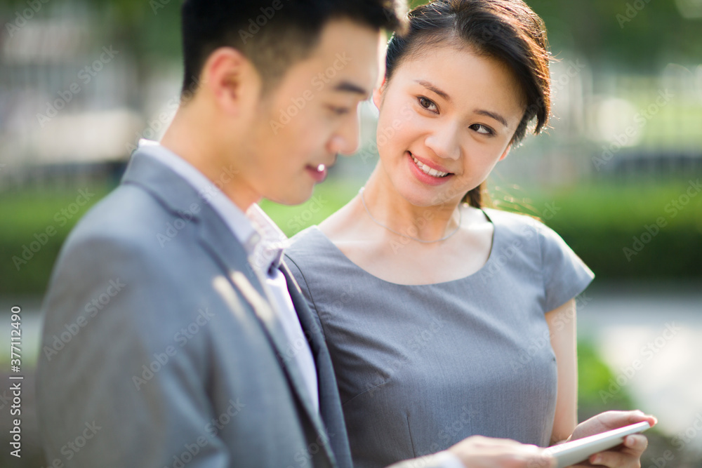 Happy businesspeople with digital tablet in discussion