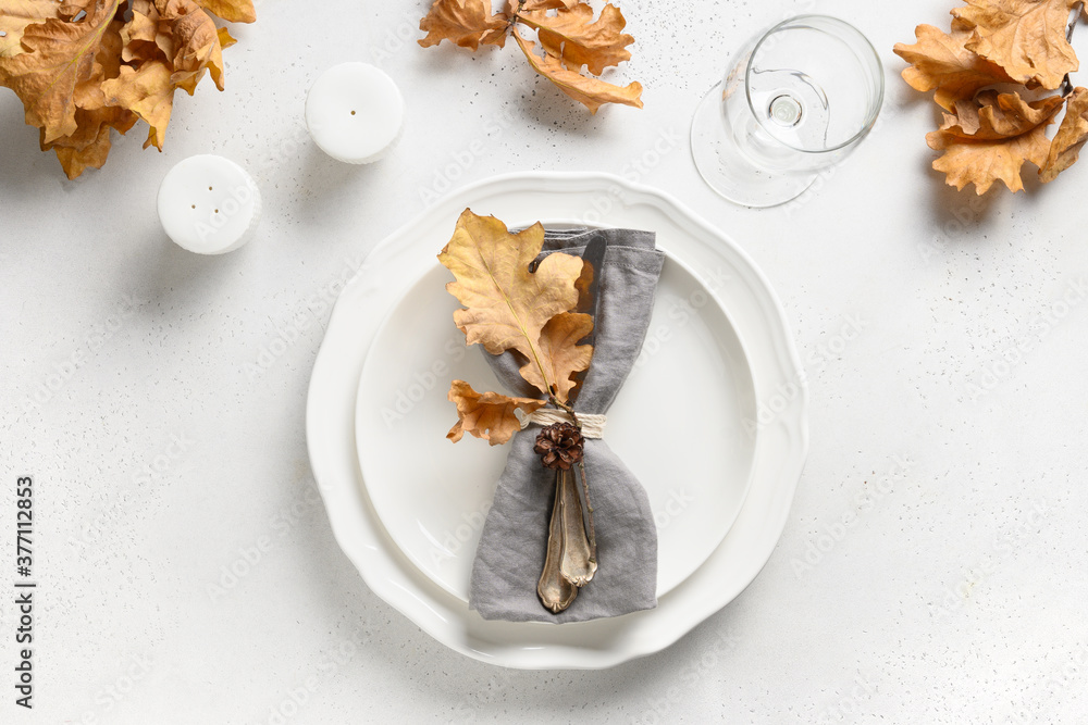 Fall table setting with autumn leaves and white plate on white table. View from above. Fall table setting with autumn leaves and white plate on white table. View from above.