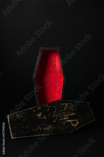 Miniature open black-red coffin on a black background. Festive halloween concept. A place for your product.