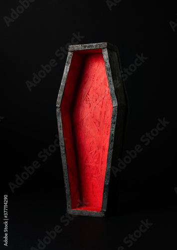 Miniature open black-red coffin on a black background. Festive halloween concept. A place for your product.