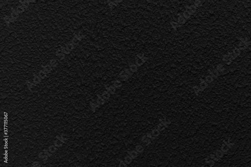 Rough patterned black cement wall texture and seamless background