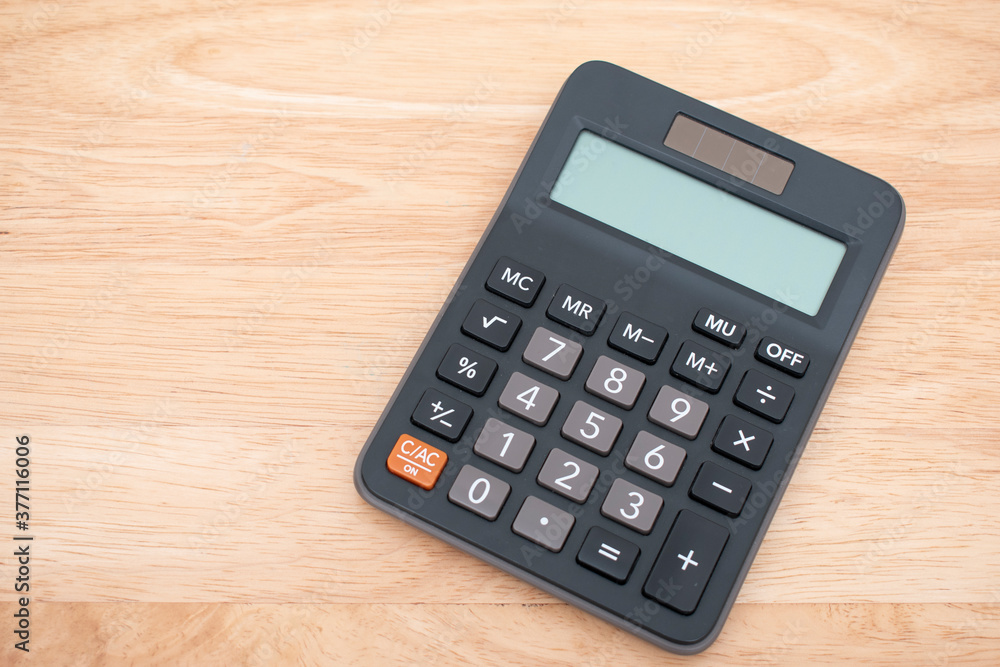 Top view Black digital calculator on wood background Top view Black digital calculator on wood background