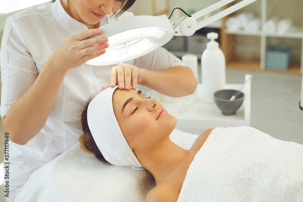 Relaxed young woman enjoying professional skincare procedures in modern beauty salon Relaxed young woman enjoying professional skincare procedures in modern beauty salon