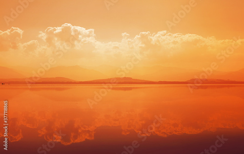 Sunset over mountain lake with reflection