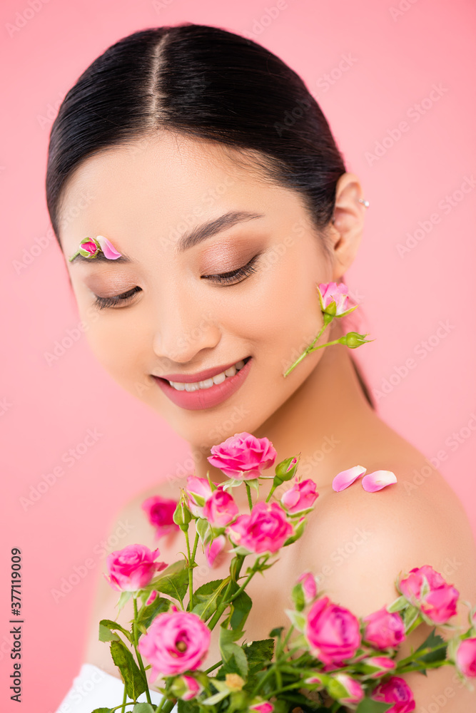 young asian woman with tiny roses and floral decoration on face isolated on pink young asian woman with tiny roses and floral decoration on face isolated on pink
