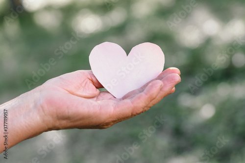 Grandma s hand holds a heart. The concept of protecting the elderly  retirement