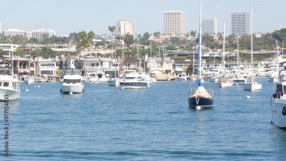 Obraz premium Newport beach harbor, weekend marina resort with yachts and sailboats, Pacific Coast, California, USA. Waterfront luxury suburb real estate in Orange County. Expensive beachfront holiday destination