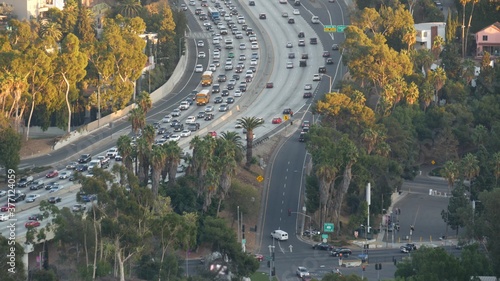 Busy rush hour intercity highway in metropolis, Los Angeles, California USA. Urban traffic jam on road in sunlight. Aerial view of cars on multiple lane driveway. Freeway with automobiles in LA city