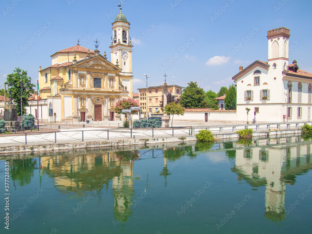 the historic center of gaggiano, in the province of Milan, reflected in the Naviglio Grande, an ancient navigable canal
