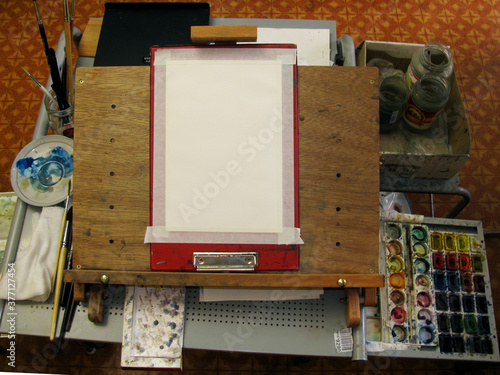 The medium-grained A4 canvas is attached to the easel with paper tape. Everything is ready for drawing. The view from the top.