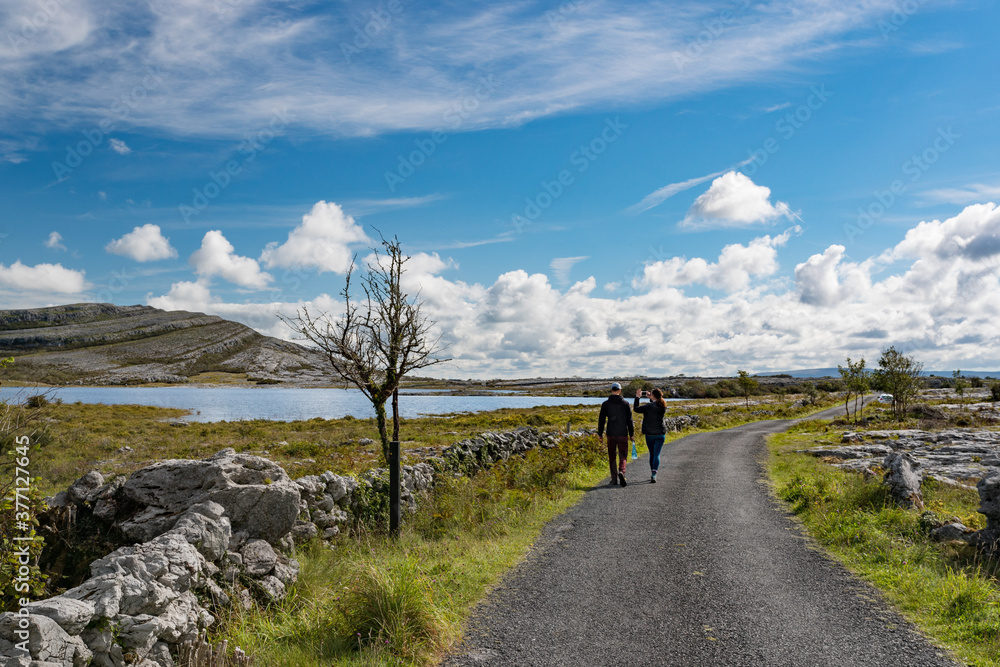 tourists walking through the Burren national park in County Clare, Ireland tourists walking through the Burren national park in County Clare, Ireland