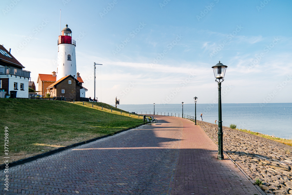 Urk Netherlands harbor and lighthouse near the beach on a bright summer day Flevoland Urk Netherlands Europe - obrazy, fototapety, plakaty 