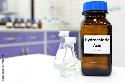 Selective focus of strong hydrochloric acid chemical in brown amber glass bottle inside a laboratory with copy space. photo