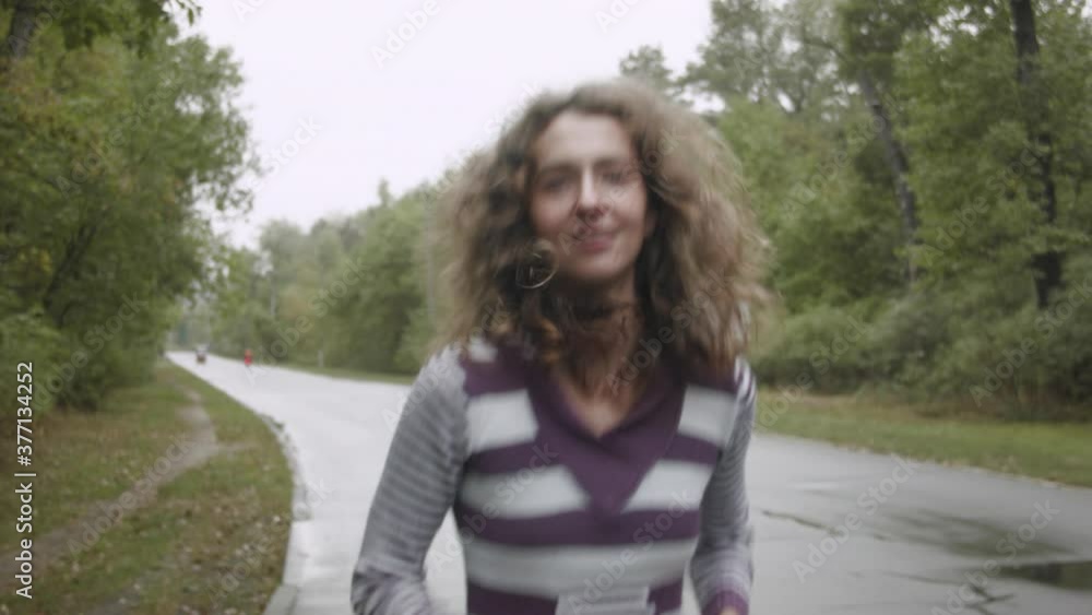 Woman doing morning jogging through the forest after rain. A woman runs along the road in the forest. Woman doing morning jogging through the forest after rain. A woman runs along the road in the forest.