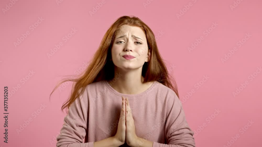 Cute young girl praying over pink background. Woman begging someone satisfy her desires, help with. Cute young girl praying over pink background. Woman begging someone satisfy her desires, help with.