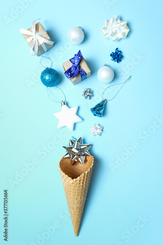 Waffle cone with christmas elements on blue background. 