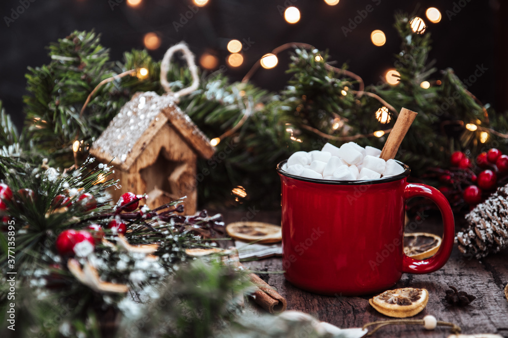 a mug of hot drink with marshmallows and cinnamon among New Year's decorations. Beautiful christmas background a mug of hot drink with marshmallows and cinnamon among New Year's decorations. Beautiful christmas background