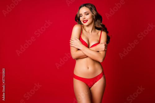 Portrait of her she nice-looking attractive lovely glamorous lovable pretty perfect stunning dreamy wavy-haired girl embracing herself isolated on bright vivid shine vibrant red color background