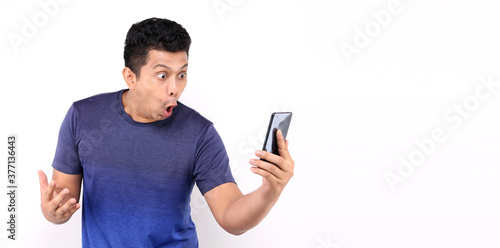 Shock and surprise face of Asian man presenting smart phone on white background in studio With copy space