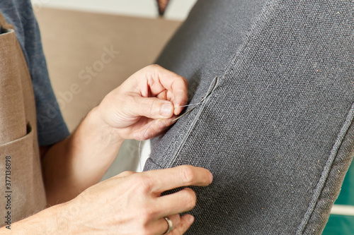 Qualified workman upholstering furniture in repair furniture