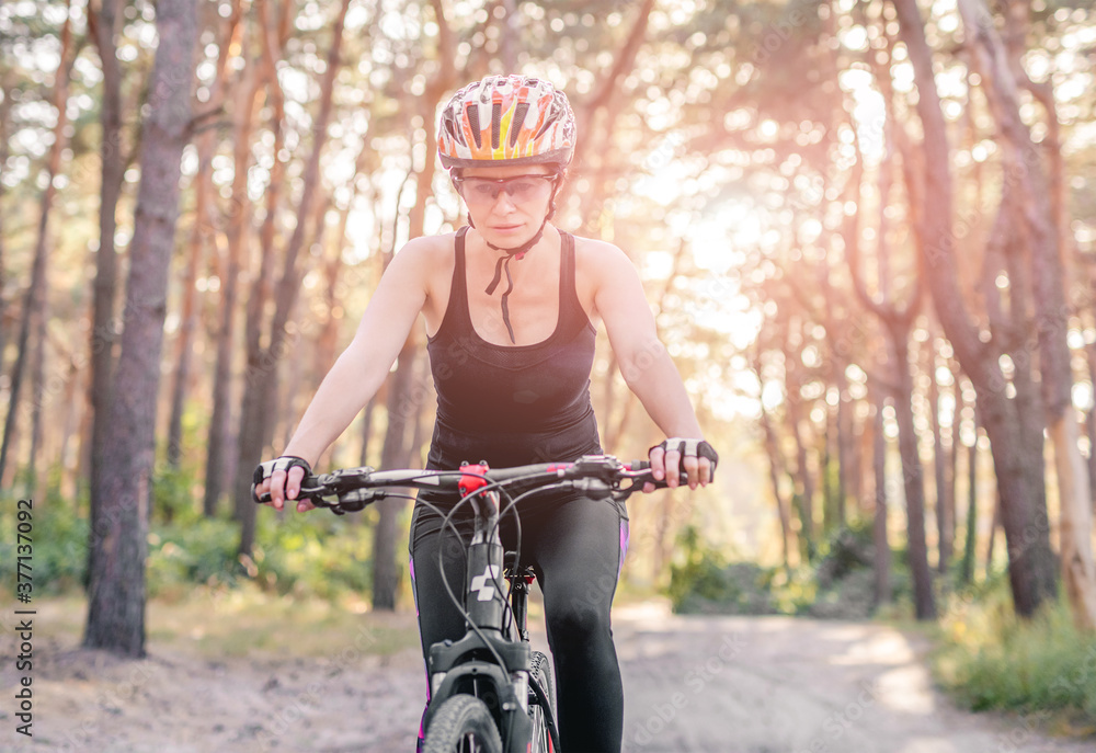 Naklejka premium Woman riding bicycle in forest
