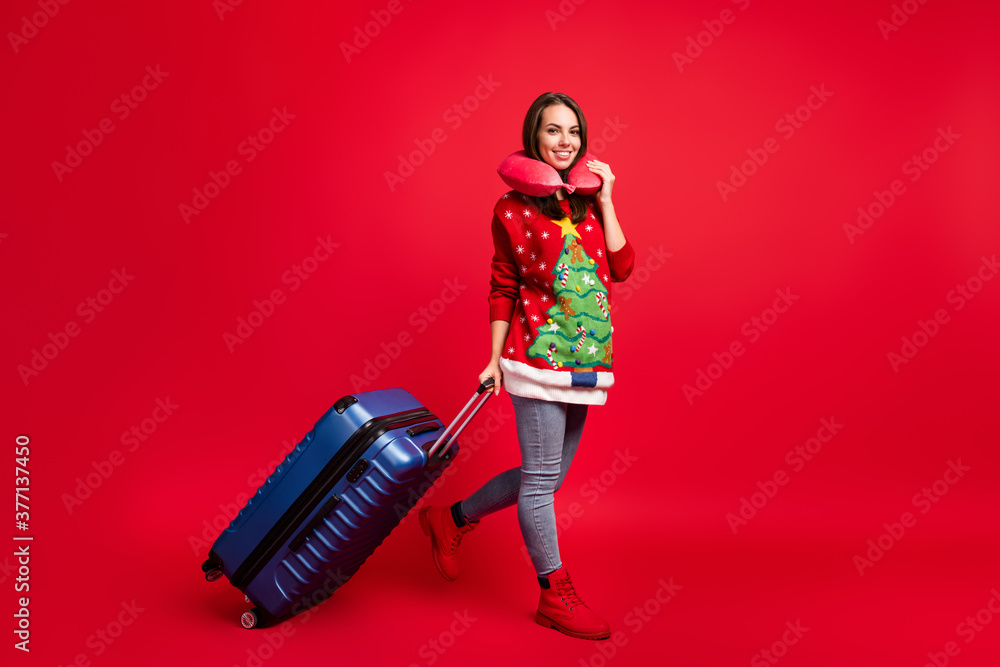 Full length body size view of her she attractive cheerful girl walking carrying baggage departure destination flight international tourism isolated bright vivid shine vibrant red color background Full length body size view of her she attractive cheerful girl walking carrying baggage departure destination flight international tourism isolated bright vivid shine vibrant red color background