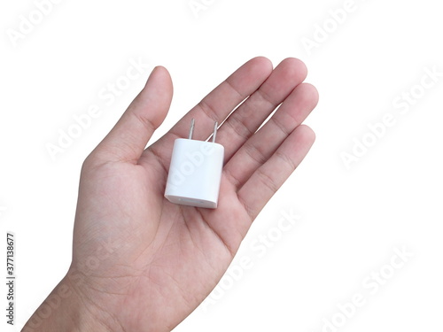 Hand holding white mobile adapter charger plug isolated on white background.