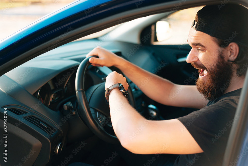 Man sitting in card at steering wheel and looking shocked at watch, delay concept