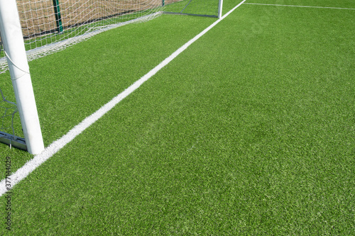 Close up of football soccer gate with white net and green grass background