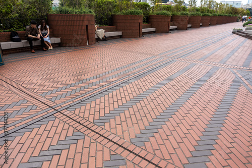 整列して配置されているベンチに座るカップル