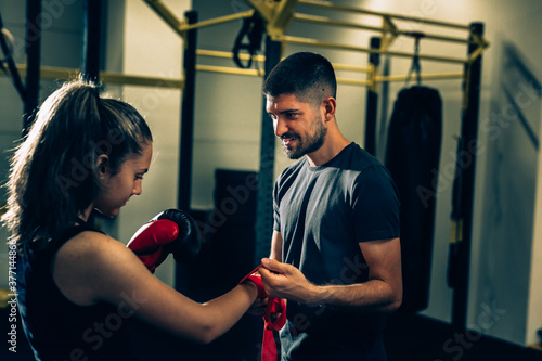 woman boxer with her trainer preparing for training