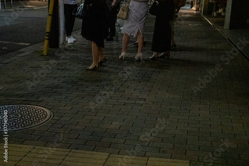 通り立っている女性たちの足