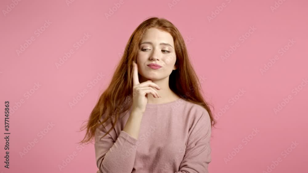 Smiling happy girl showing eureka gesture. Portrait of young thinking pondering woman having idea moment pointing finger up on pink studio background. Smiling happy girl showing eureka gesture. Portrait of young thinking pondering woman having idea moment pointing finger up on pink studio background.
