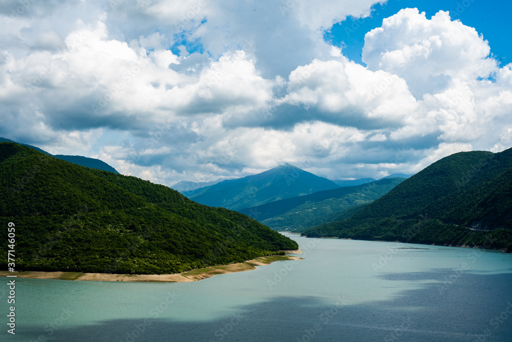 Obraz premium mountain lake with blue turquoise clear water against the backdrop of a clear sky and mountain hills