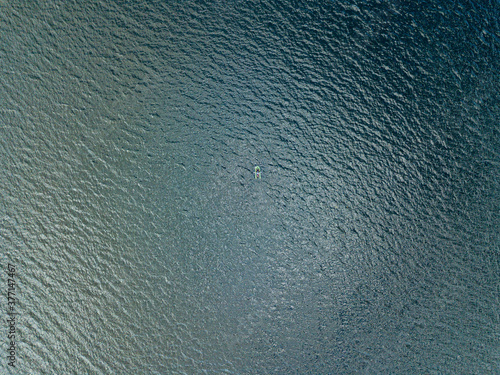 Aerial drone view. Fishing boat on the waves of the river.