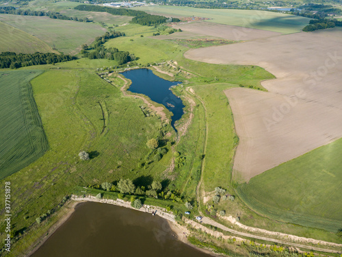 Lake among agricultural fields. Aerial drone view.