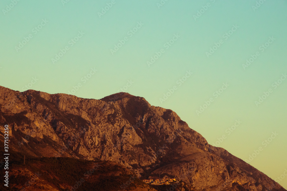 Sunset pale landscape of mountains next to the adriatic sea, atmospheric photo in warm film colors