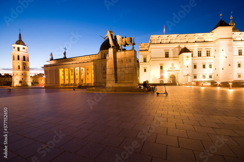 Night view of illuminated Cathedral Square in the Old Town of Vilnius, Lithuania. Cathedral Basilica of St Stanislaus and St Ladislaus on left, monument to Gediminas in center, Royal Palace on right