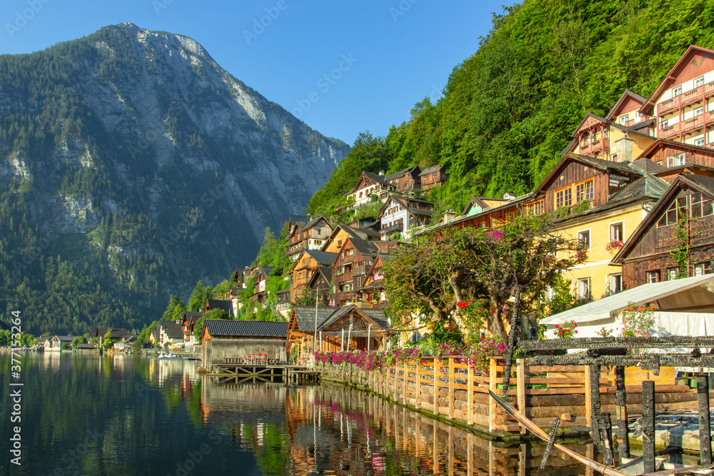 Naklejka premium Classic postcard view of famous Hallstatt lakeside town, Austria. Scenic panoramic view of beautiful town reflecting in Hallstatter See.Beautiful sunny day in summer, Salzkammergut region.Urban scene