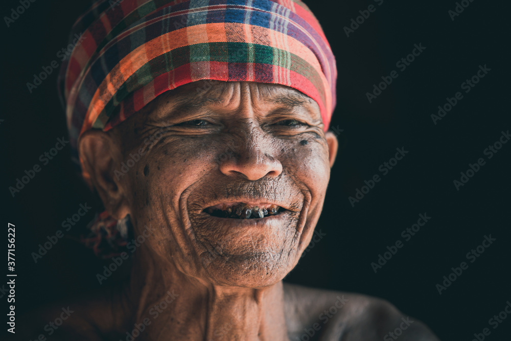 Smiling of Asian elderly man sitting alone in the countryside, wrinkled skin, gray hair, 70 years old, close-up view Thailand. Smiling of Asian elderly man sitting alone in the countryside, wrinkled skin, gray hair, 70 years old, close-up view Thailand.