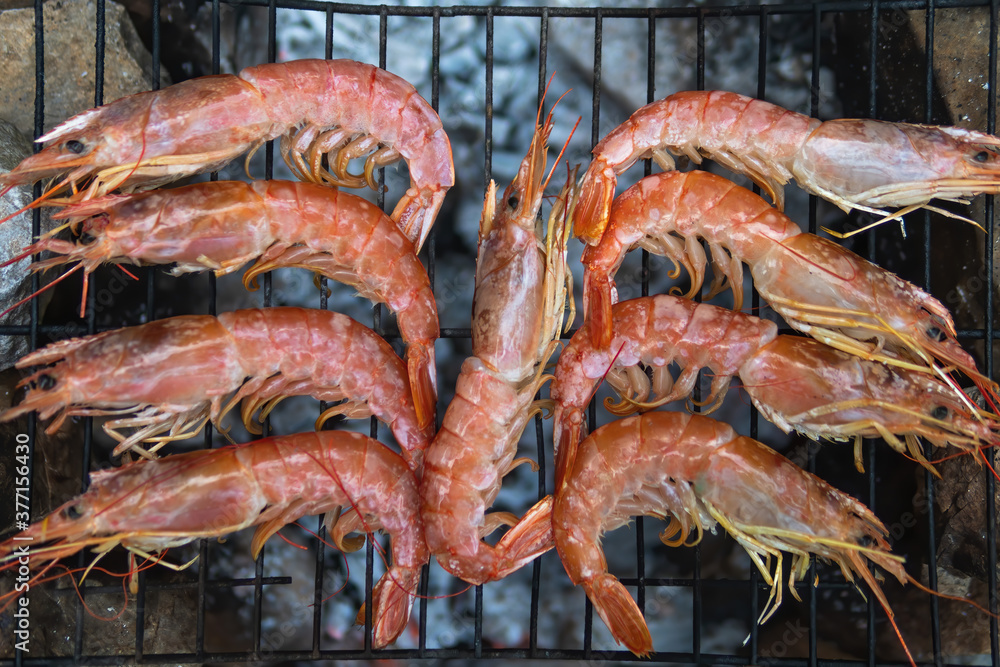 Large Argentine shrimp. Cooking at the stake. Grilled food. Natural conditions. Seafood. Bonfire.