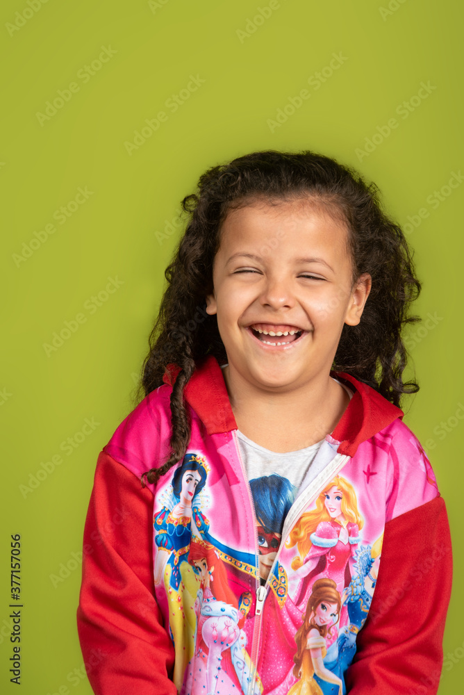 Happy and playing child and smiling, with green background and selective focus. Happy and playing child and smiling, with green background and selective focus.