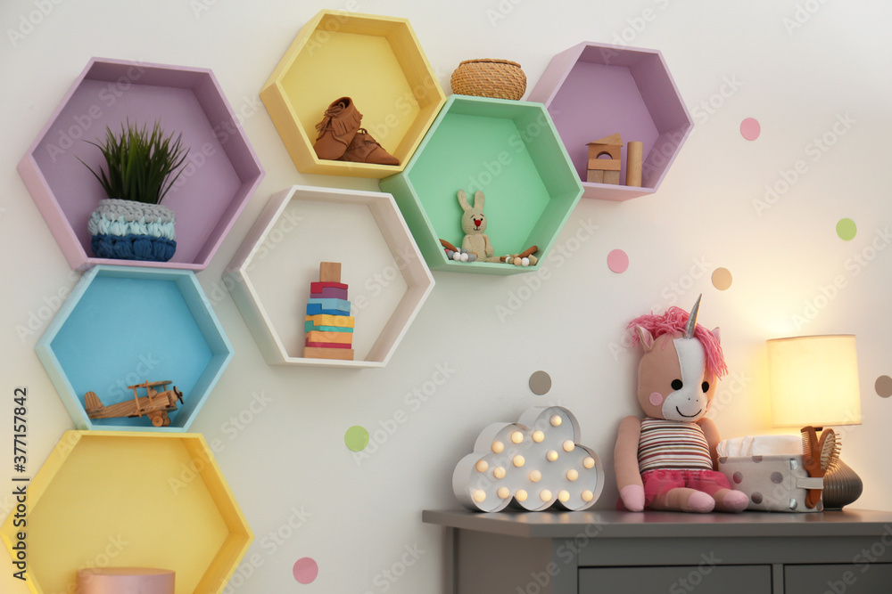 Bright colorful shelves on light wall in room. Interior design Bright colorful shelves on light wall in room. Interior design